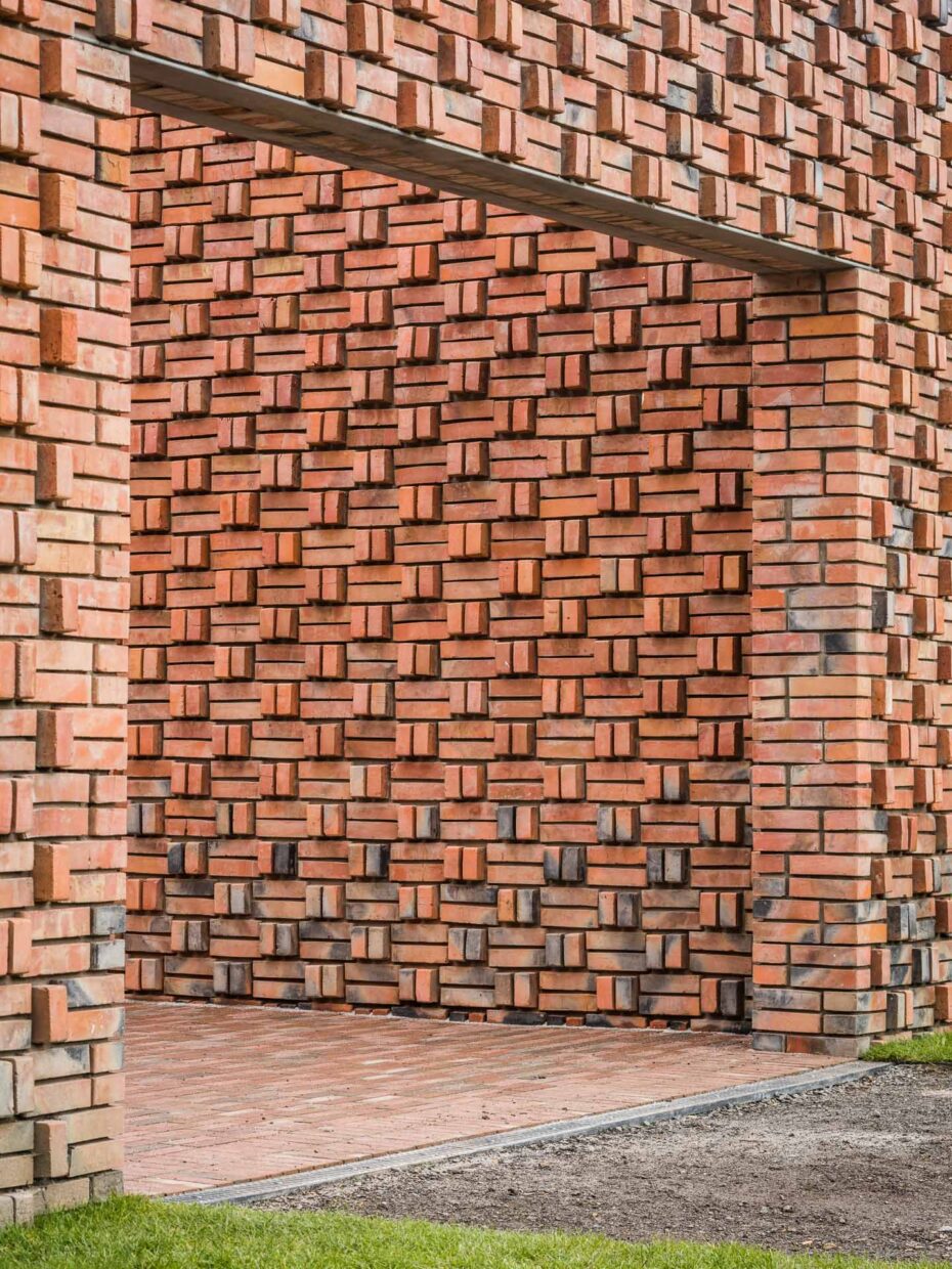Wjazd dla samochodu przez ceglane ogrodzenie
