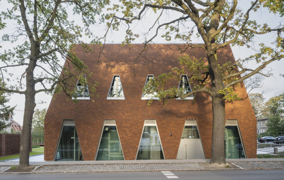 widok na budynek publiczny z ceglaną elewacją i przeszkleniami
