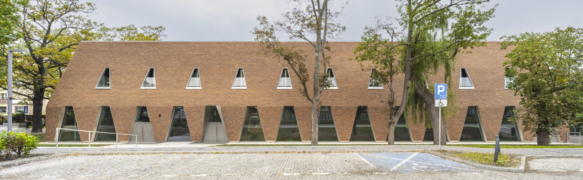 ceglana elewacja budynku publicznego z przeszkleniami