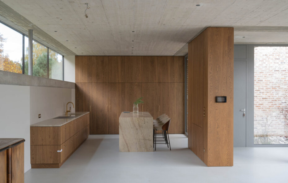 Kuchnia z drewnianym wykończeniem i jasną wyspą z kamienia