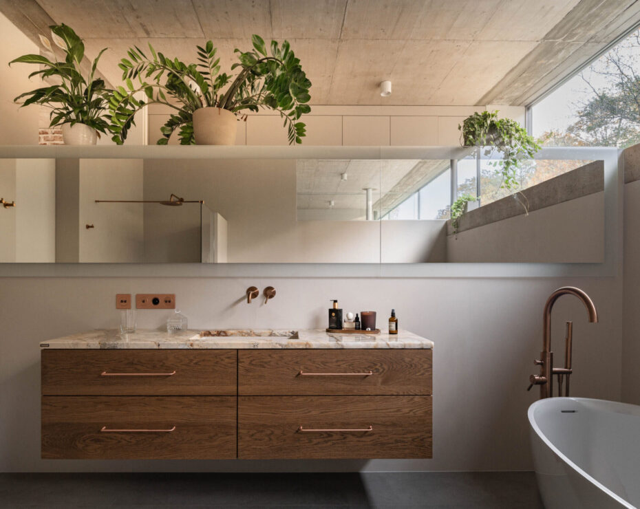 Łazienka domu jednorodzinnego z dużym poziomym lustrem dwoma umywalkami i wanną