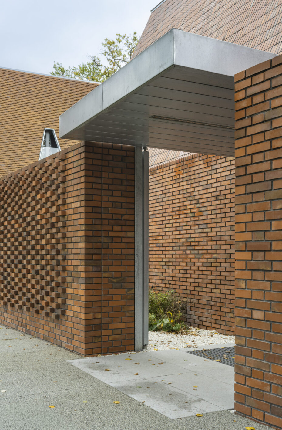 Brama wejściowa do budynku publicznego w ceglanym ogrodzeniu